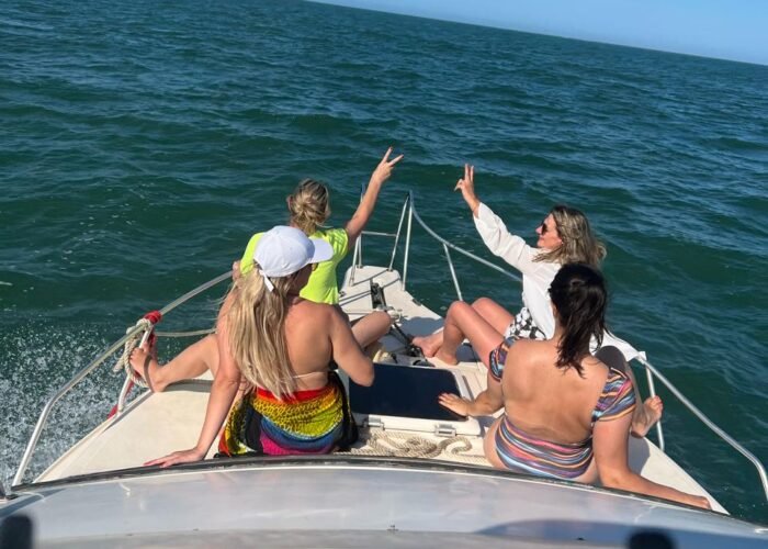 Quatro amigas celebrando na proa da Lancha Oceanic 26 em águas abertas