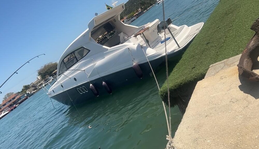 Lancha Coral 43 HT ancorada no Canal do Itajuru em Cabo Frio com céu azul