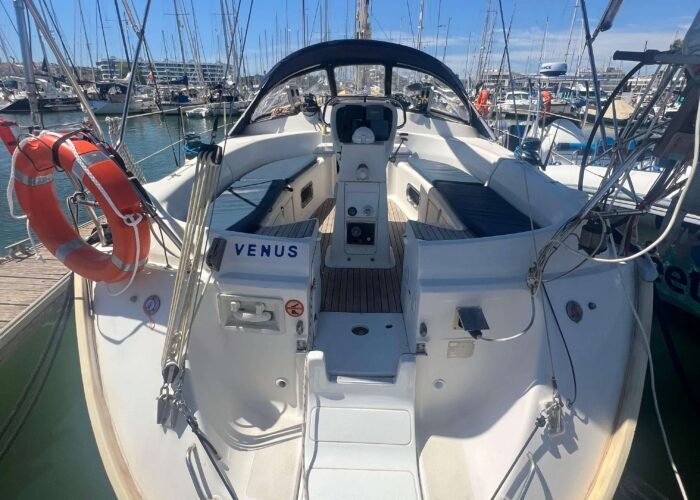 Popa do veleiro Bavaria 40 com bimini, cockpit, boia salva-vidas e plataforma de banho, atracado em marina