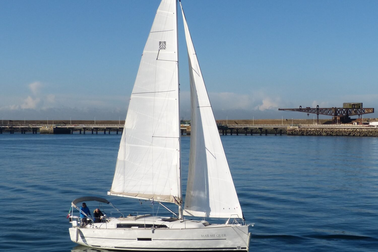 Veleiro Dufour 360 em pleno movimento, com suas velas abertas e tripulantes a bordo.