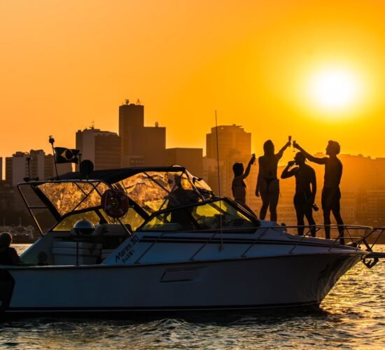 Lancha Mares 30 com passageiros brindando ao pôr do sol no Rio de Janeiro.