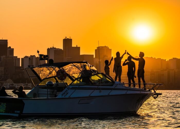 Lancha Mares 30 com passageiros brindando ao pôr do sol no Rio de Janeiro.