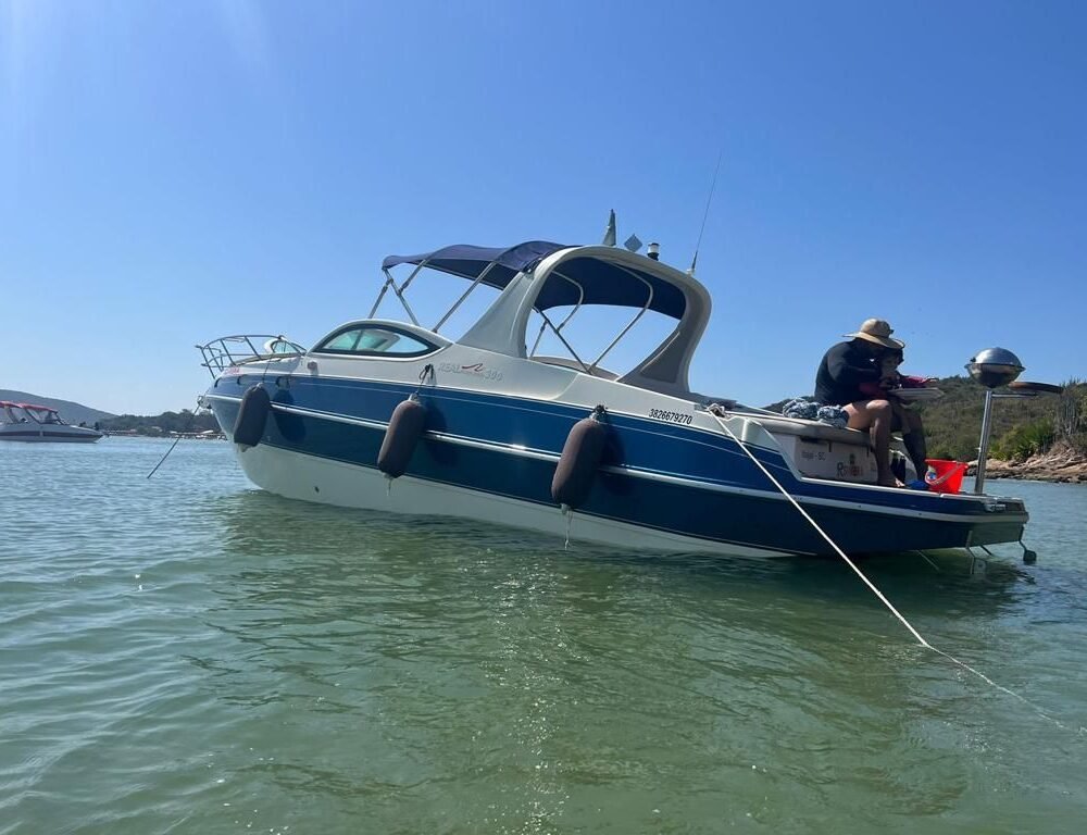 Vista lateral da Lancha Real Powerboat 30 pés ancorada próximo à margem.