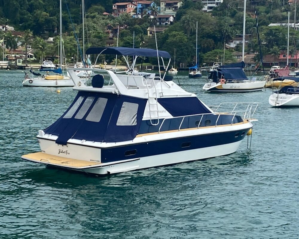 Vista traseira da Lancha Oceanic 32 em Angra dos Reis, ancorada em um local paradisíaco, ideal para aluguel de lancha.