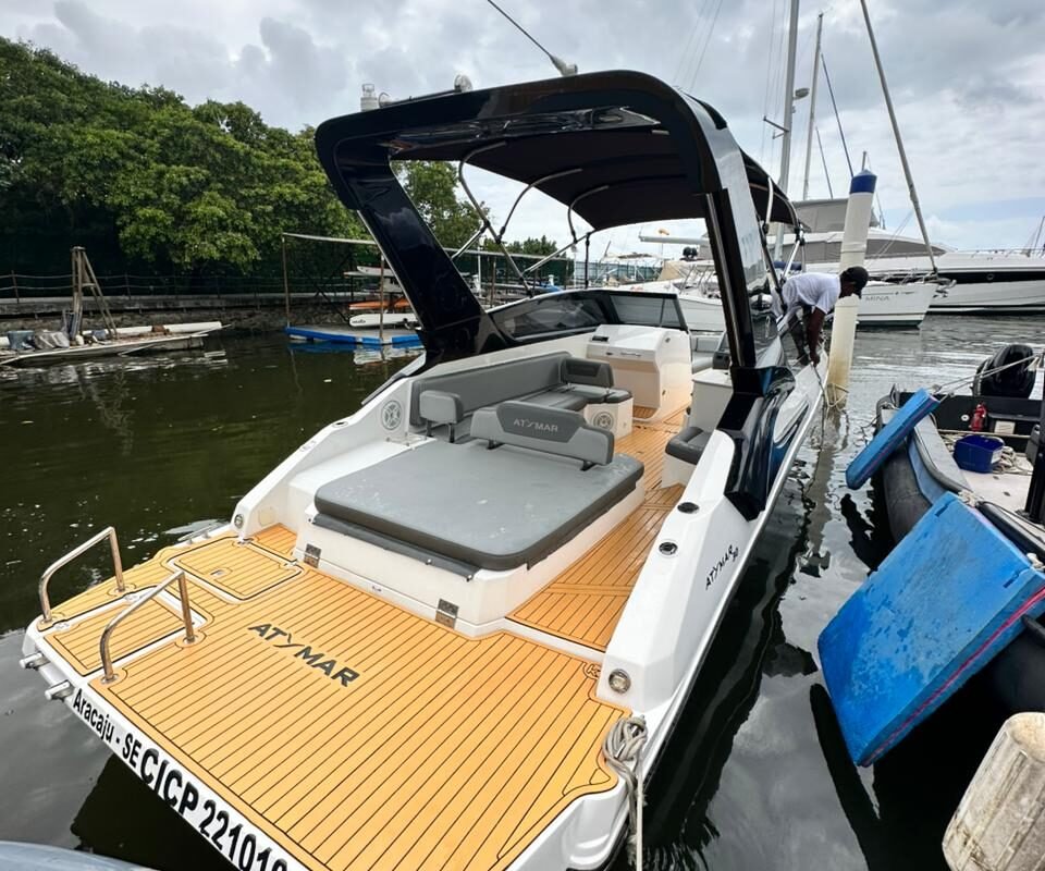 Lancha Atymar 30 atracada no píer, destacando a elegância do deck traseiro em madeira e espaço amplo.