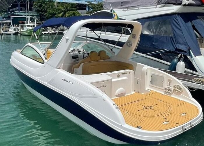 Lancha Coral 27 ancorada em Angra dos Reis, com design elegante e detalhes em azul e branco.