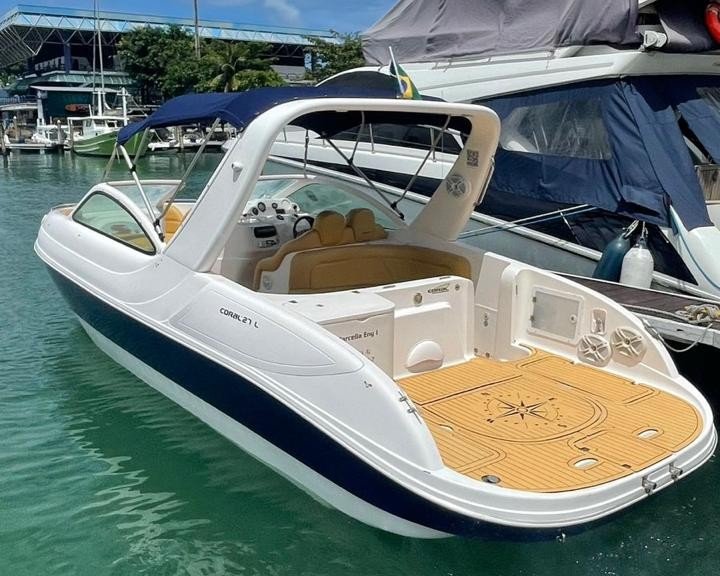 Lancha Coral 27 ancorada em Angra dos Reis, com design elegante e detalhes em azul e branco.