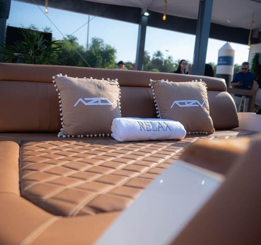 Detalhe de área relaxante da lancha AZOV Z380s com almofadas e toalha “Relax.”