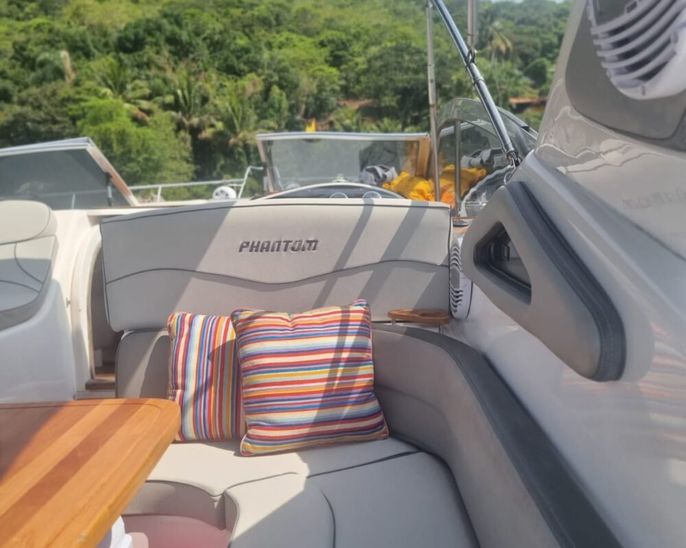 Espaço acolhedor com almofadas coloridas na área de convivência da lancha Phantom 290 em Angra dos Reis.