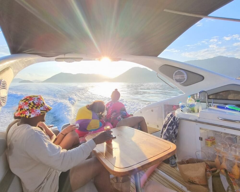 Pessoas relaxando a bordo de uma lancha Phantom 29 em Angra dos Reis durante um passeio privativo ao pôr do sol.