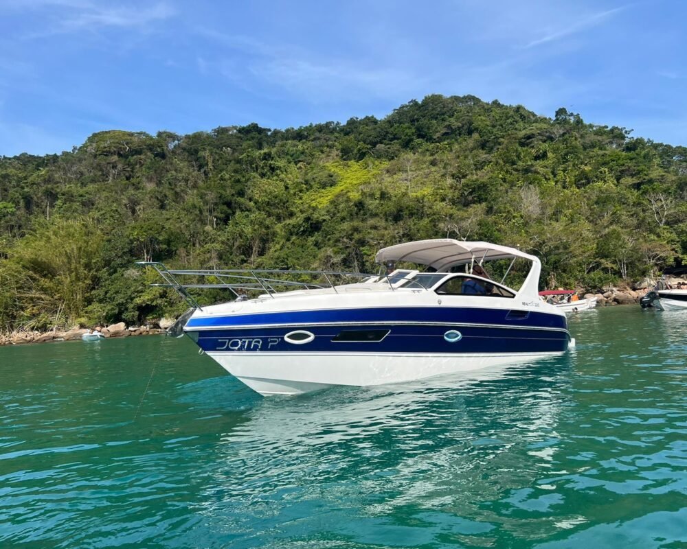 Lancha Real 32 navegando em águas cristalinas de Angra dos Reis, ideal para aluguel e passeios exclusivos.