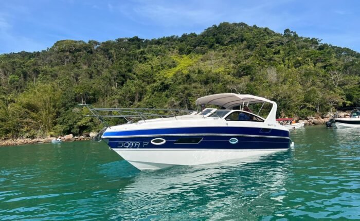 Lancha Real 32 navegando em águas cristalinas de Angra dos Reis, ideal para aluguel e passeios exclusivos.