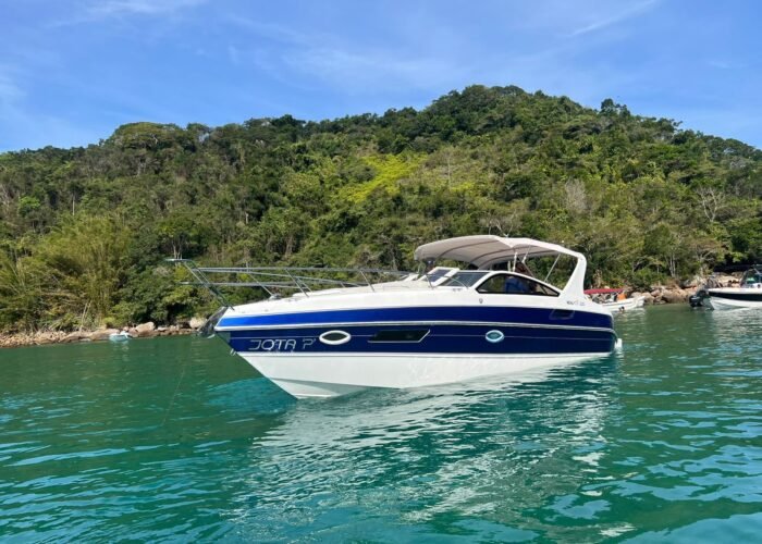 Lancha Real 32 navegando em águas cristalinas de Angra dos Reis, ideal para aluguel e passeios exclusivos.