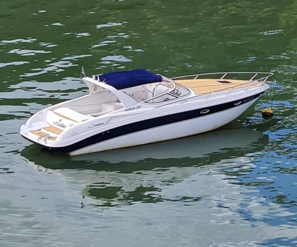 Vista aérea da lancha Runner 29 ancorada em águas cristalinas de Angra dos Reis, pronta para aluguel.