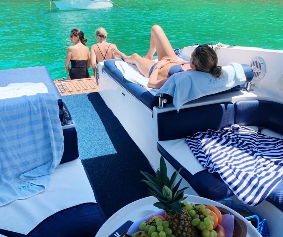 Área externa da Lancha Runner 38 com passageiros relaxando em passeio em Búzios.