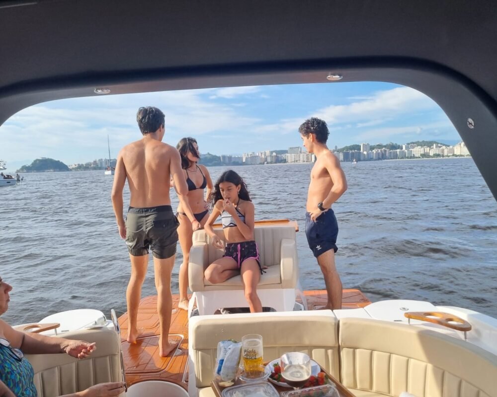 Grupo de amigos aproveitando o passeio na lancha Coral 26, navegando pela Baía de Guanabara.