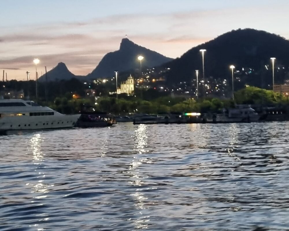 Vista do Cristo Redentor e da Igreja da Glória ao entardecer, capturada durante um passeio de barco.