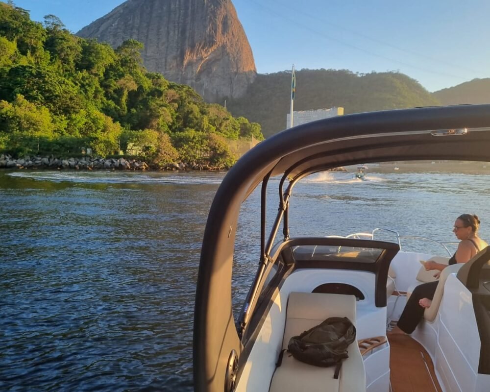 Lancha Coral 26 navegando próximo ao Pão de Açúcar, com vista privilegiada do cartão-postal carioca.