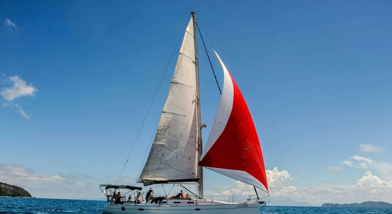 Veleiro Delta 45 com velas içadas navegando em mar aberto sob céu azul