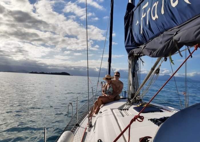 Casal no passeio de barco no convés do veleiro Delta 36' em Paraty