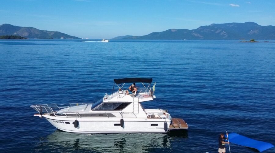 Lancha Oceanic 36 flutuando em Angra dos Reis com prancha de stand-up