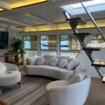 Sala de estar do Catamarã Artesanal com TV e sofás, disponível para aluguel em Angra dos Reis.