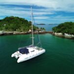 Catamarã Fountaine Pajot 46 pés ancorado próximo a praia com coqueiros em Paraty