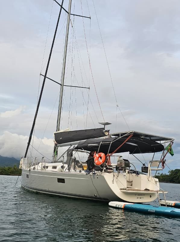 Veleiro Delta 41 ancorado em Paraty visto de perfil na água.