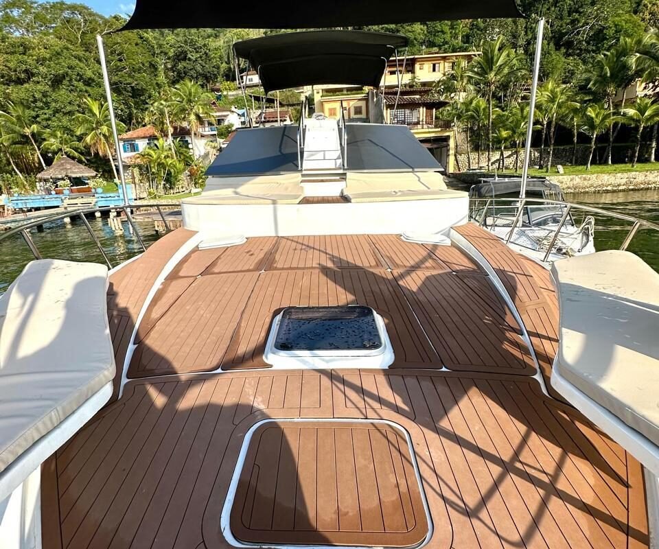 Área de solário na proa do Yacht Mares 600 Malik com deck em madeira.