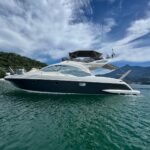 Vista lateral completa da Lancha Azimut 43 ancorada em Angra dos Reis com mar esverdeado