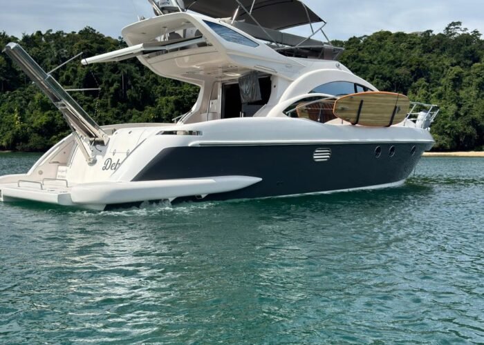 Lancha Azimut 43 ancorada em Angra dos Reis, vista de popa com plataforma e bandeira