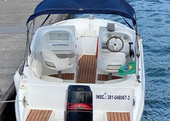 Lancha Alternativa 22 atracada na marina, vista de popa, com toldo, dois assentos de comando e piso náutico