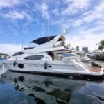 Iate Segue 72 Fly atracado na marina, com flybridge, bimini azul e reflexo do casco na água
