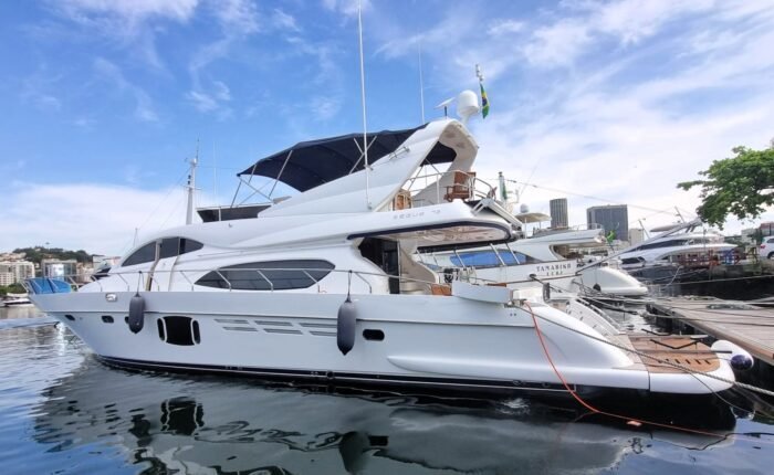 Iate Segue 72 Fly atracado na marina, com flybridge, bimini azul e reflexo do casco na água
